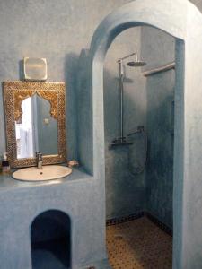 La salle de bains est pourvue d'un lavabo et d'une douche avec un miroir. dans l'établissement Dar Mussarat, à Essaouira