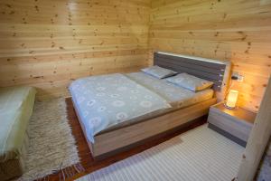 een slaapkamer met een bed in een houten kamer bij ŠIBALIĆ APARTMANI in Žabljak