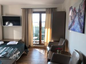 a hotel room with a bed and a chair at Breeze Guest House in Chernomorets