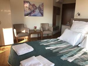 a bedroom with a bed with two towels on it at Breeze Guest House in Chernomorets