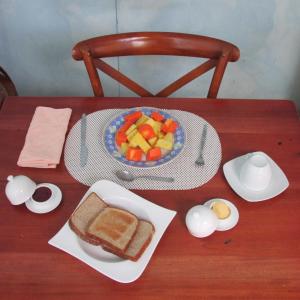 una mesa con un sándwich y un plato de fruta en Casa Leon Guesthouse, en San José