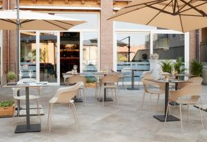 a restaurant with tables and chairs and umbrellas at HILL COLLE - camere & bistrot in Erbusco