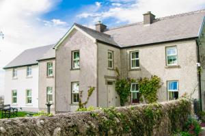 una casa con una pared de piedra delante de ella en Corrib View Farmhouse, en Galway