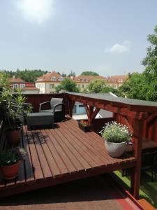 terraza de madera con mesa y sillas en el balcón en Penzion U Papoušků, en Jindřichův Hradec