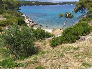 a beach with people swimming in the water at Apartments 1st line to sea and beach,quiet area,private parking,terrace with sea view in Jelsa