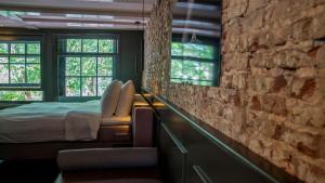 sypialnia z łóżkiem i ceglaną ścianą w obiekcie Hotel Frank since 1666 w Amsterdamie