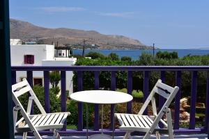two chairs and a table on a balcony with a table at Nefeli Hotel Leros in Agia Marina