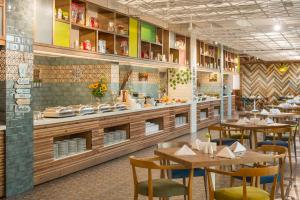 a restaurant with wooden tables and chairs and a counter at Sunrise Blue Magic Resort - All Inclusive in Obzor