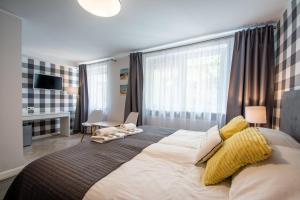 a bedroom with a large bed and a desk at Beach House - przy plaży in Sopot