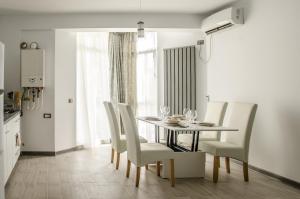 a dining room with a table and white chairs at Apartamente Azzurro on the beach in Mamaia Sat/Năvodari