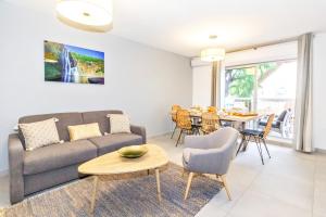 un soggiorno con divano e tavolo di Pinacle - beau duplex refait à neuf proche plage a Saint-Gilles-les Bains