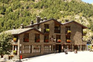 卡尼略Hotel L’Ermita B&B的一座大建筑,窗户上放着鲜花