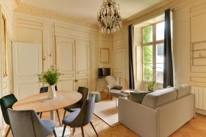 een woonkamer met een tafel en een bank bij La Suite de Pauline - Appt au coeur de Rennes in Rennes