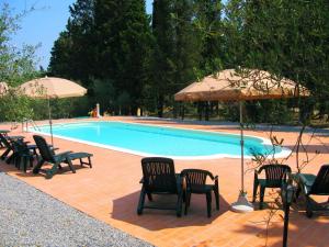 un groupe de chaises et de parasols à côté d'une piscine dans l'établissement Agriturismo Martignana Alta, à Empoli