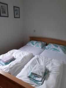 - un lit avec des draps blancs et des serviettes dans l'établissement Zonnig zomerhuis, à Krachtighuizen