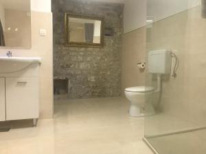 une salle de bains avec toilettes, lavabo et miroir dans l'établissement Bounty Apartments, à Šibenik 38 autres photos