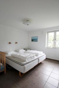 a white bedroom with a large bed in it at Villa M in Simrishamn
