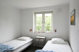 two twin beds in a room with a window at Villa M in Simrishamn
