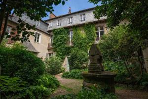 een met klimop bedekt gebouw met een standbeeld ervoor bij La Suite de Pauline - Appt au coeur de Rennes in Rennes