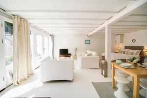 a white living room with a bed and a desk at The Retreat Studio in Carlisle