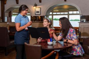 three women sitting at a table with a laptop at The Wooden House - Room Only Accomodation in Kilmore Quay