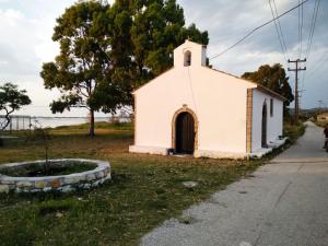 una pequeña iglesia blanca al lado de una carretera en Christiana's cottage house Lygia en Lygia