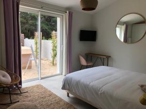 Le Grand VieilにあるLes Gîtes de la Clereのベッドと鏡と窓のある寝室