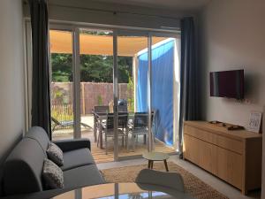 a living room with a couch and a sliding glass door at Les Gîtes de la Clere in Le Grand Vieil