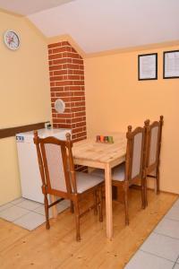 een keuken met een houten tafel en stoelen bij Apartman Viktorija in Krapinske Toplice
