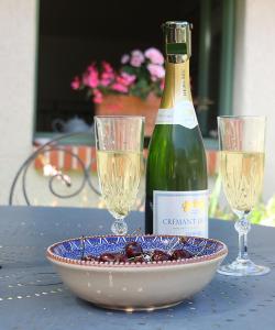 a bottle of wine and two glasses on a table at Le Logis du Pressoir Chambre d'Hotes Bed & Breakfast in beautiful 18th Century Estate in the heart of the Loire Valley with heated pool and extensive grounds in Brion