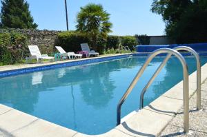 uma piscina com duas espreguiçadeiras em Les Rossignal em Villiers-le-Roux