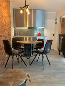 a dining room with a table and chairs and a kitchen at Resort 36 in Mikołajki