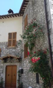 a stone building with flowers on the side of it at Agriturismo Terramia in Meggiano