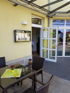 a patio with a wooden table and chairs and a window at Warias Hotel & Restaurant am Geiseltalsee - Nähe Merseburg in Braunsbedra +37 photos