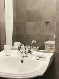 een badkamer met een wastafel en een spiegel bij Family Hel in Hel