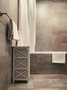 a bathroom with a shower and a cabinet with a tub at Family Hel in Hel