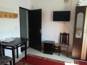 a room with a table and a desk and a television at Casa Mărguța in Iaşi