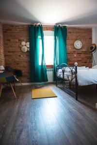 een slaapkamer met een bed en een raam met groene gordijnen bij Leon's Rooms in Żary
