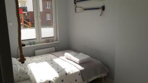 a small room with a bed and a window at Apartament Nadmorski LUX1 in Sztutowo