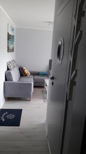 salon z kanapą i drzwiami w obiekcie Apartament Nadmorski LUX1 w Sztutowie