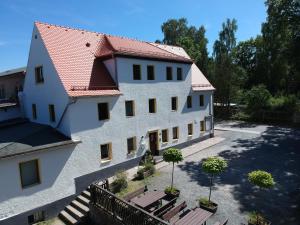 an external view of a building with benches and trees at Sennerhütte Landhotel in Kurort Gohrisch