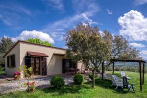 una casa con tavolo e sedie nel cortile di Agriturismo Il Canterino a Guardistallo