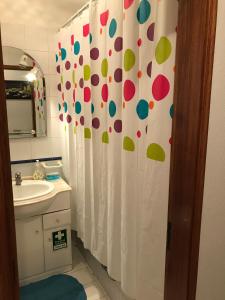 a bathroom with a shower curtain with polka dots at Caravela B in Armação de Pêra