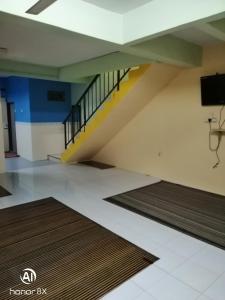 an empty room with stairs and rugs at BB HOMESTAY in Kampung Tualang