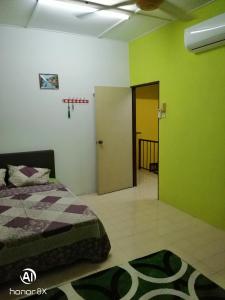 a bedroom with green and white walls and a bed at BB HOMESTAY in Kampung Tualang