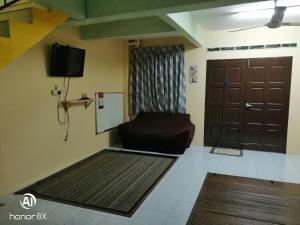 a living room with a chair and a door at BB HOMESTAY in Kampung Tualang
