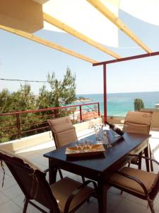 a table and chairs on a balcony with the ocean at Markella's Paradise in Kavála