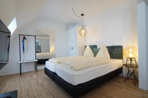 a bedroom with a white bed and a mirror at Design Hotel Sophie´s in Norderney