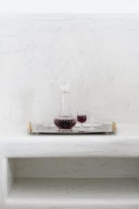 una mesa blanca con un jarrón de cristal y un plato en Oasis Hotel, en Fira