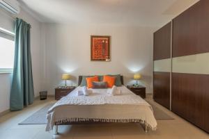 a bedroom with a large bed with orange pillows at Valletta Penthouse in Valletta